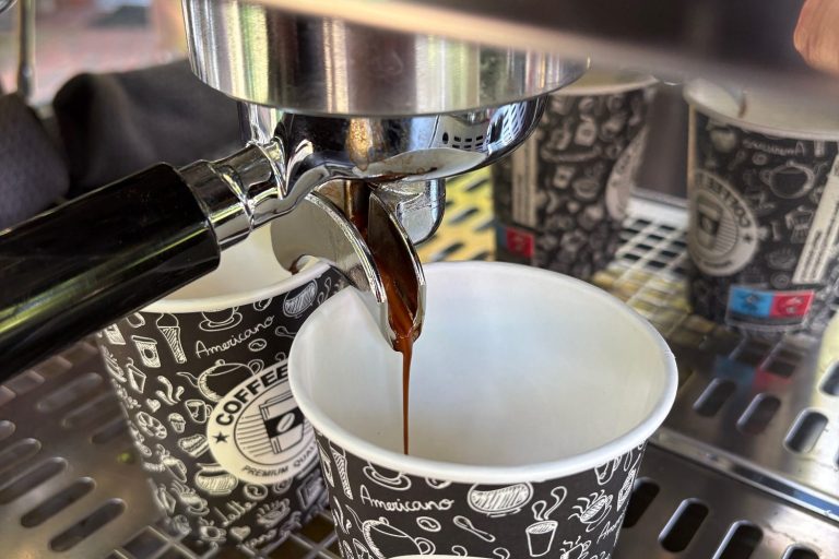 Espresso läuft frisch in einen Becher